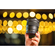 The Canon 45mm f/1/2 STM lens being held up against a backgruond of soft, roudned orange colors