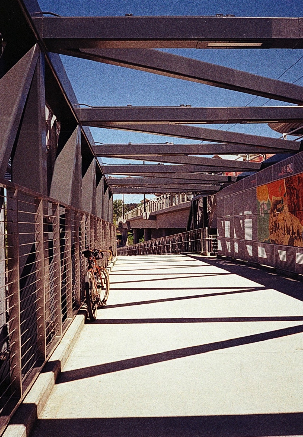A bicycle against the fence of a pedestritan bridge. 