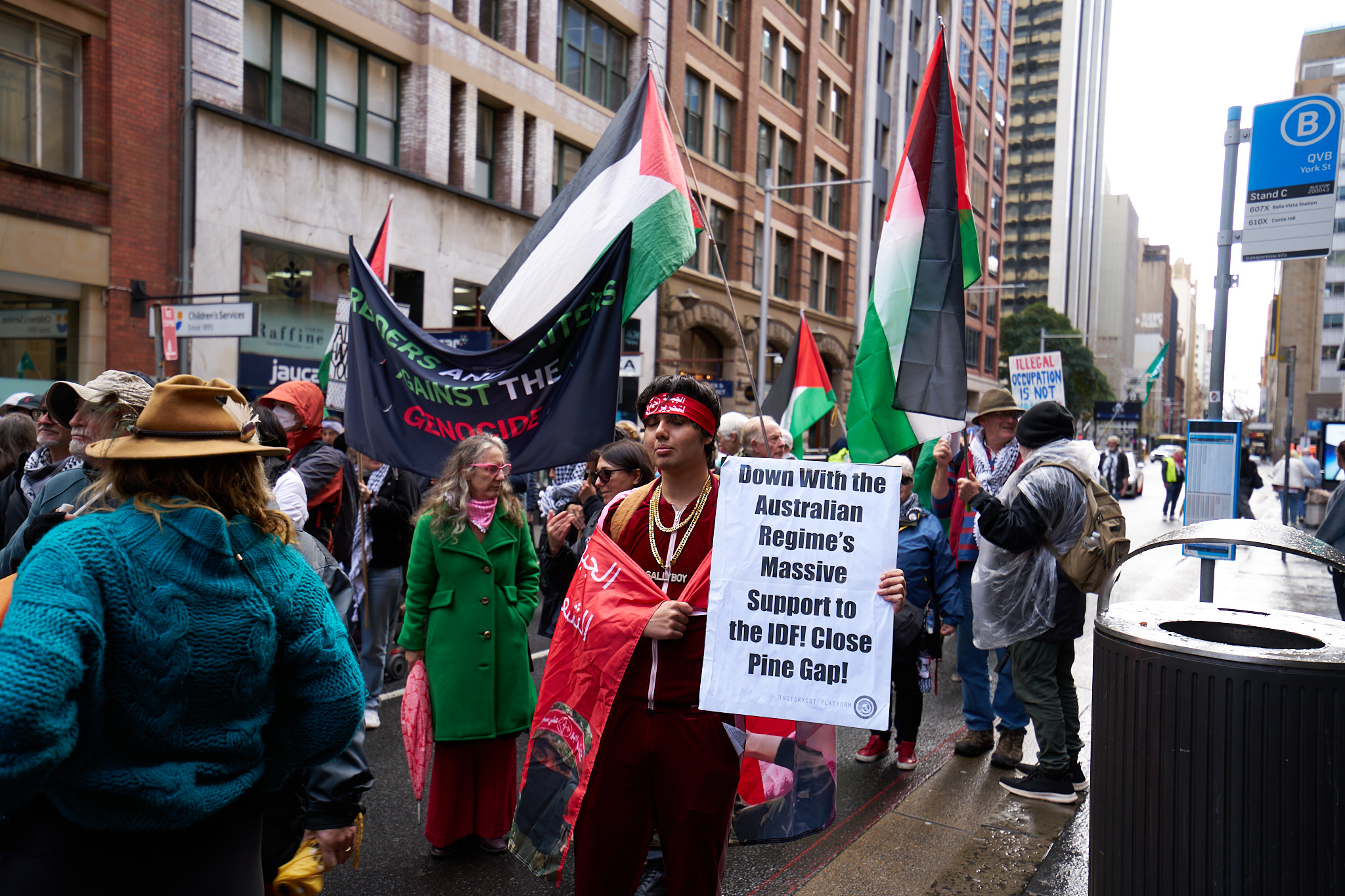 A political protest in Sydney, Australia, with protesters holding signs.